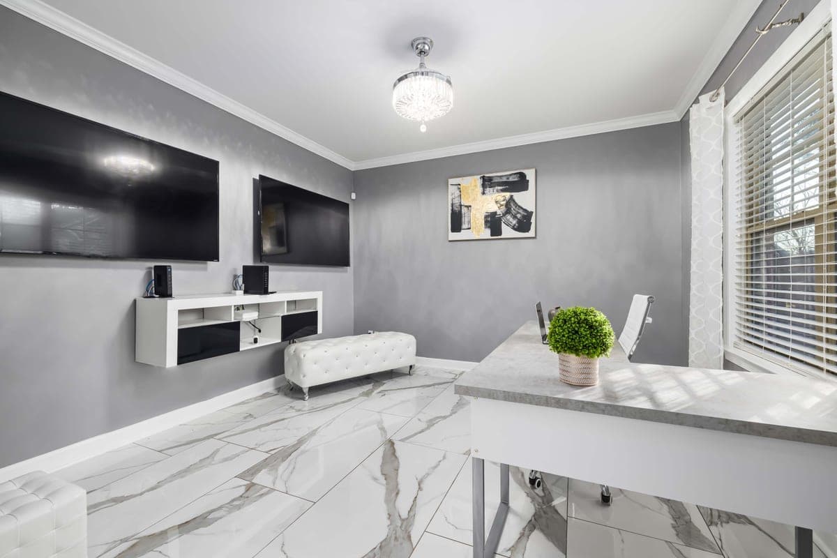 Two wall-mounted televisions above a floating console in a bright room