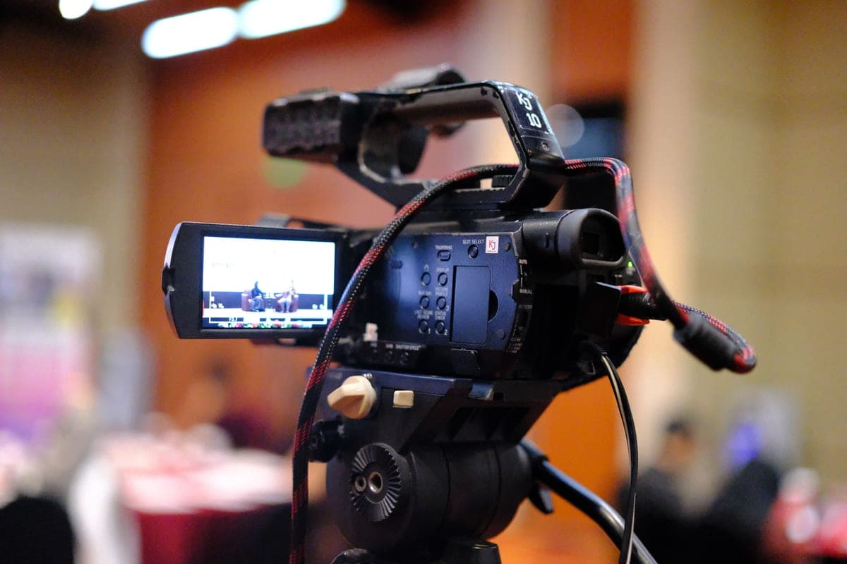 Video camera recording a presentation at an indoor business conference