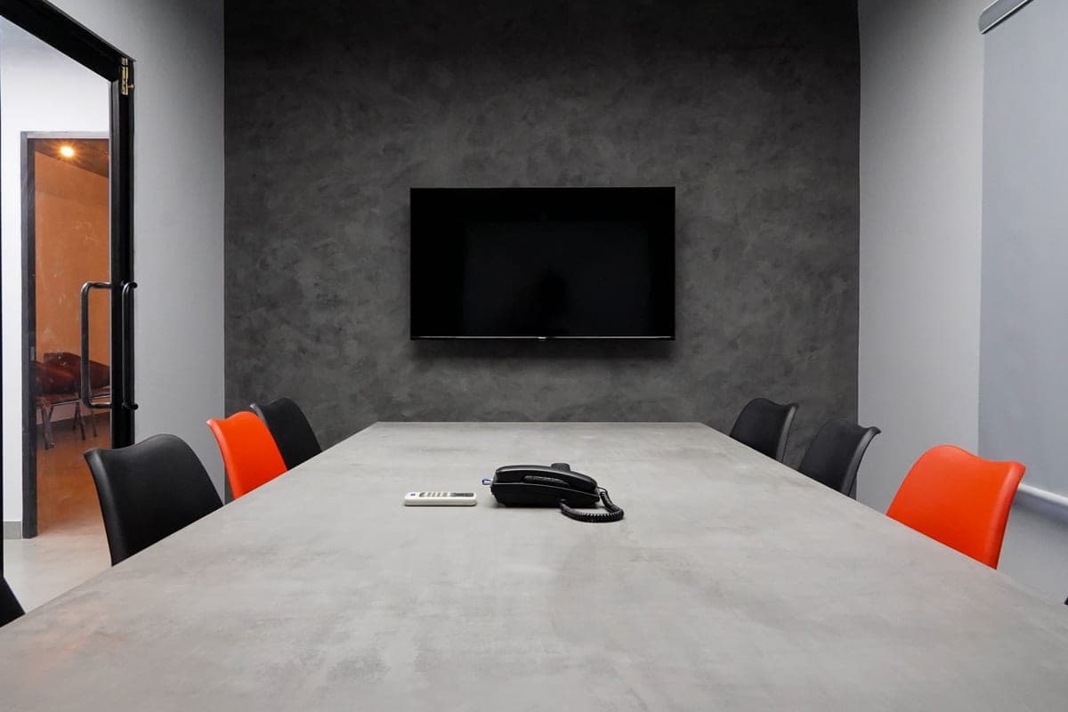 Conference room with a long table and a wall-mounted display